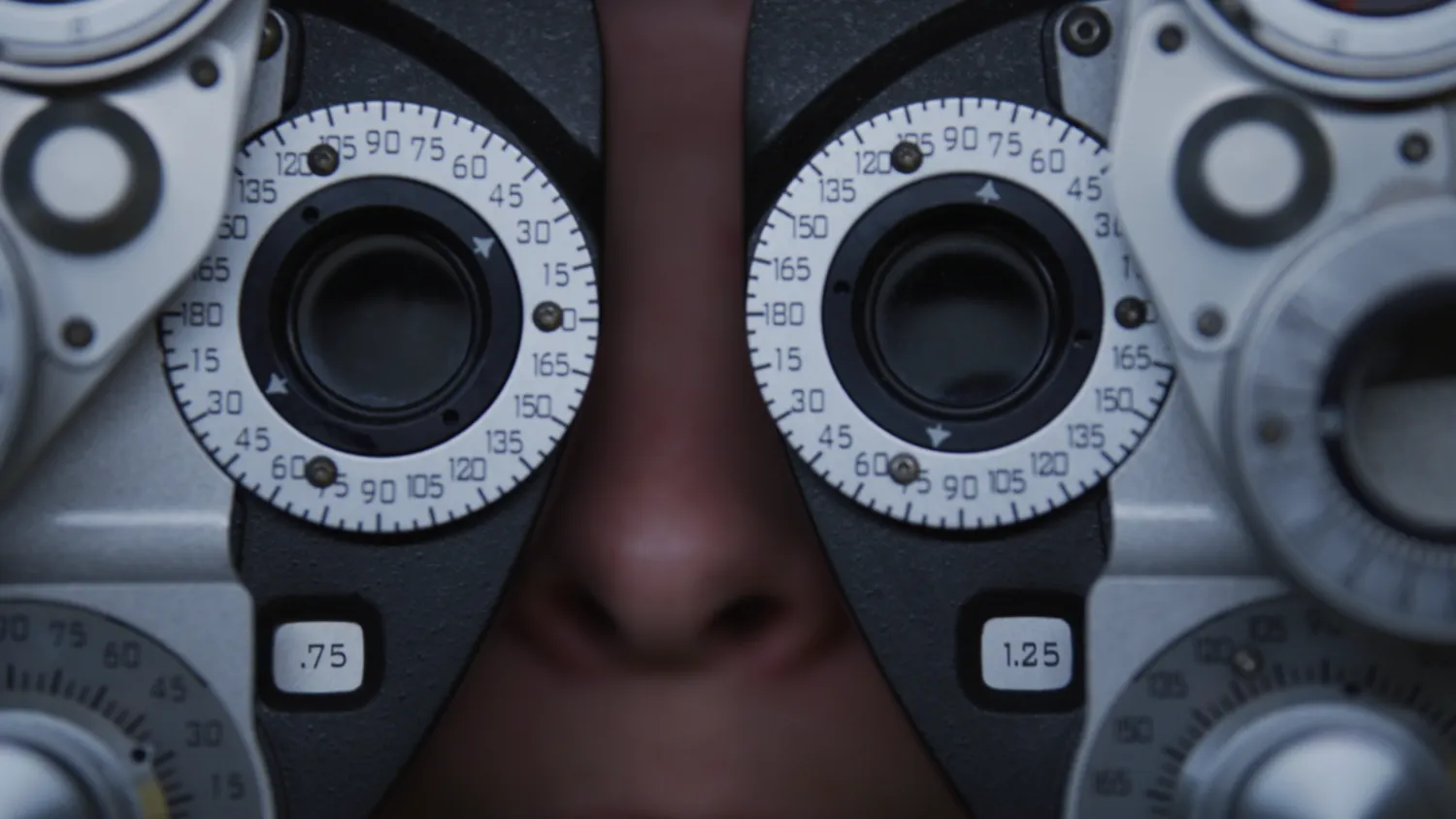 A patient looking through an optometrist’s phoropter